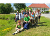 Wandergruppe in Oberösterreich vor einem Gebäude mit rotem Dach.