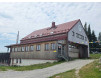 Berghütte in den österreichischen Alpen mit roten Dach und Holzfassade.